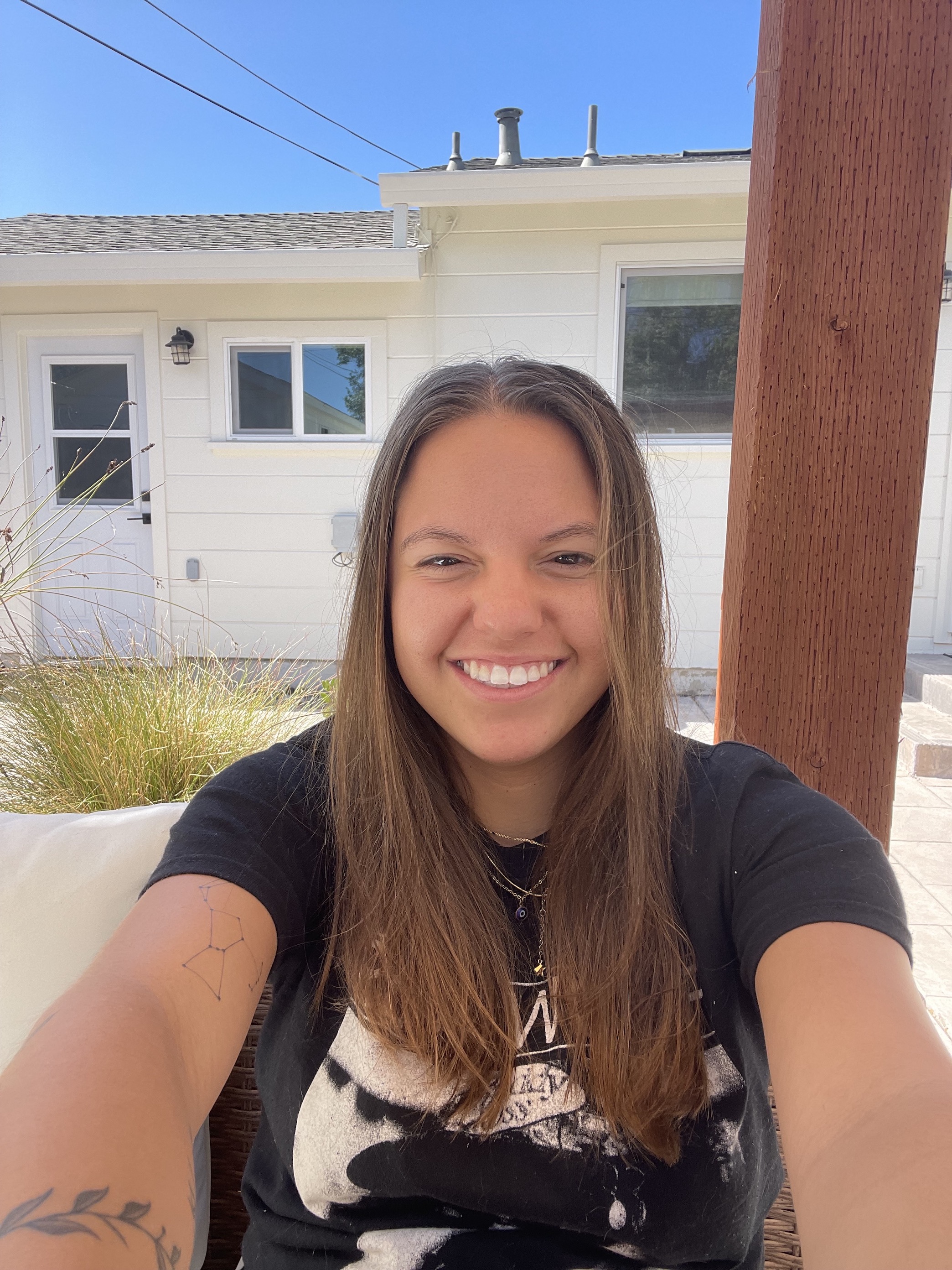 Selfie of Eva with a white building in the background.