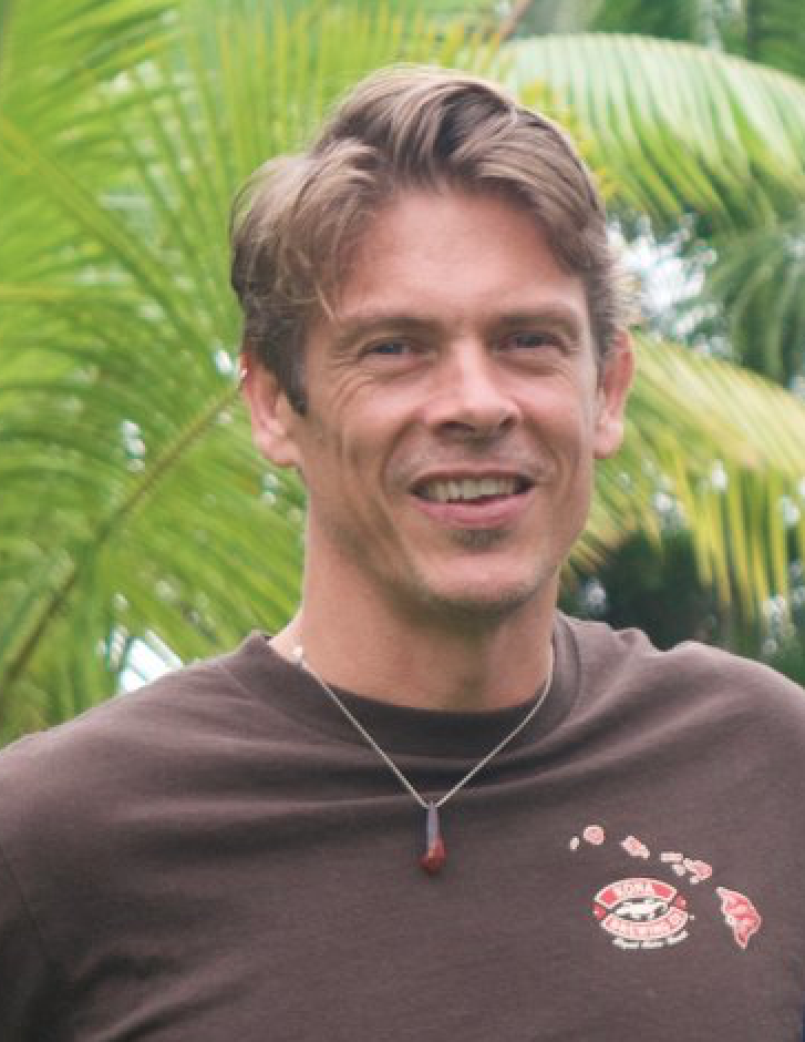 Headshot of Tam with a palm tree in the background.