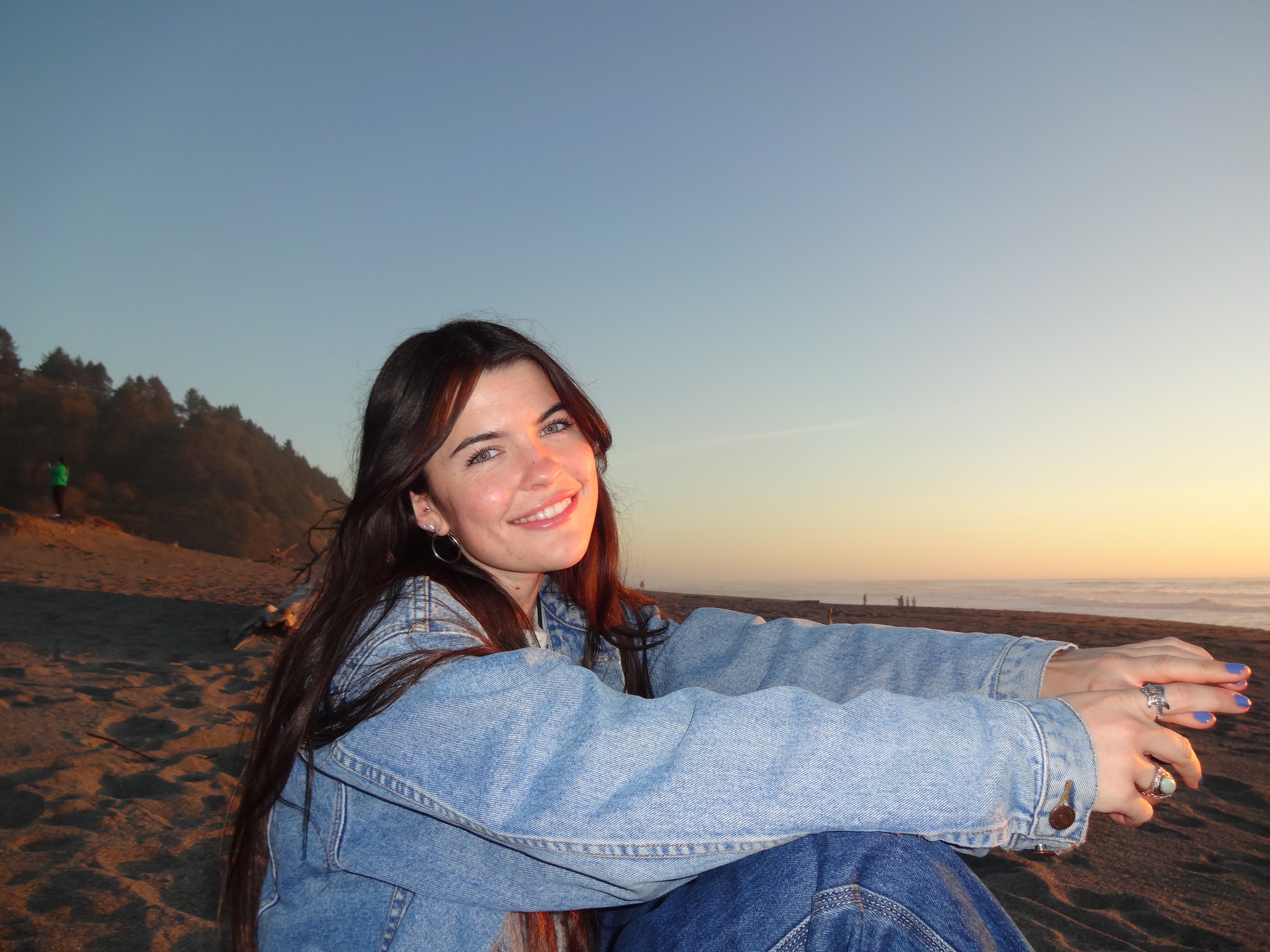 Headshot of Kyla with a sunset beach in the background.