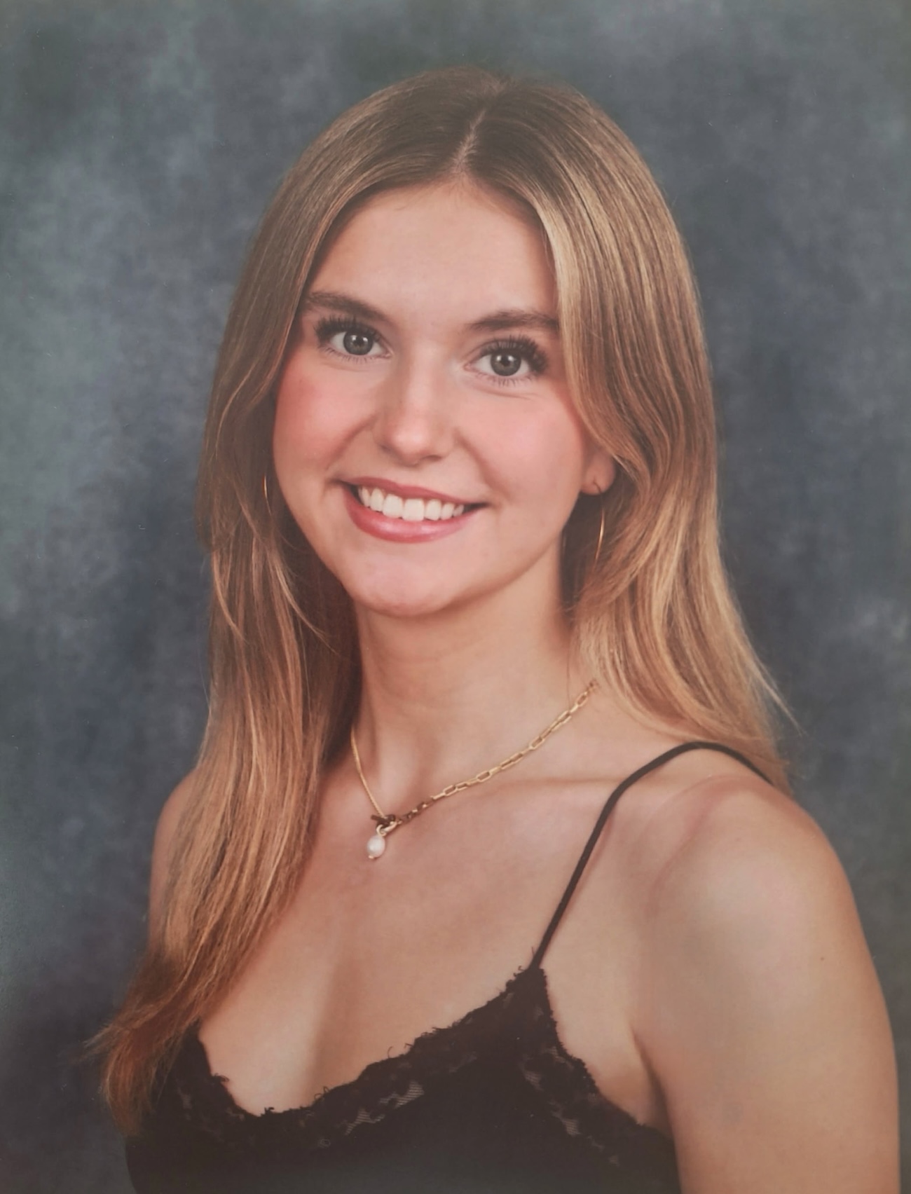 Professional headshot of Ava against a smokey background.