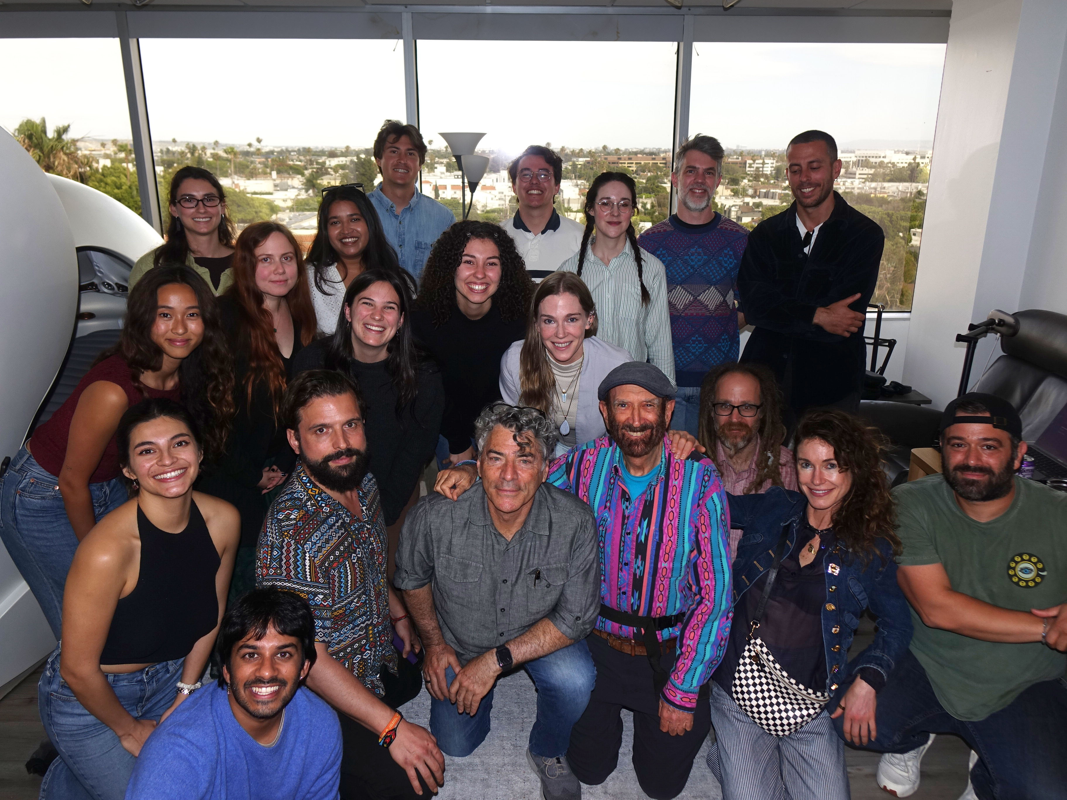 META Lab members gathered with the IACS lab members in front of a large window.